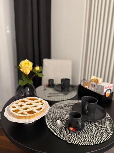 a black table with a waffle and two plates and cups at Panta Rei Camere di Charme e Spa in Taranto