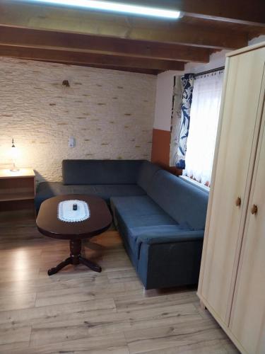 a living room with a blue couch and a table at Penzion u Šmídů Náměstí in Jaroslavice