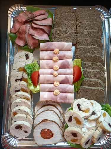 a tray of food with meats and vegetables on it at GLASHÜTTE Kisújbánya Vadászház in Hosszúhétény