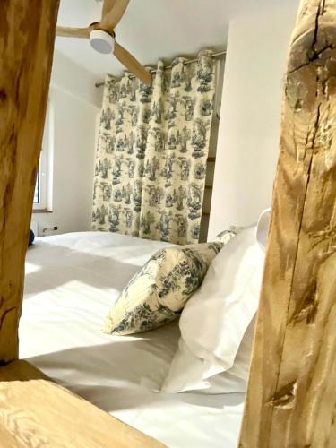 une chambre avec un lit avec des draps blancs et des oreillers dans l'établissement Studio Cathédrale, à Strasbourg