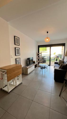 un salon avec un canapé et une table dans l'établissement Appartement T2 - Rez-de-Jardin, proche plage et commerces, à Calvi