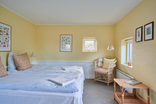 a bedroom with a bed and a table and a chair at Hjorths Badehotel in Kandestederne