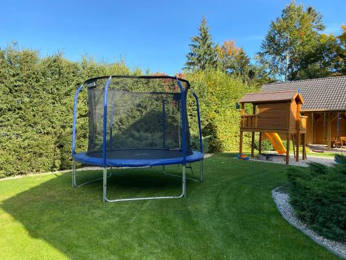 a blue trampoline in a yard with a house at Chata Sidorka in Oravský Podzámok