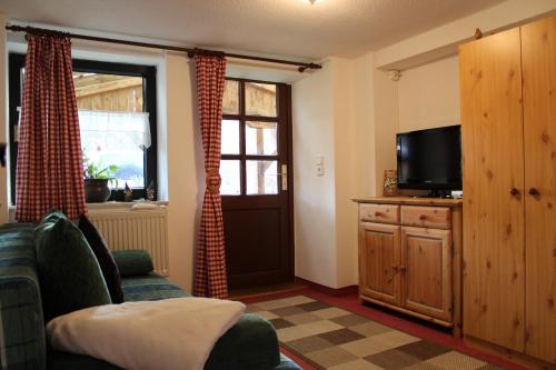 a living room with a couch and a television at Walnußhof in Schmogrow