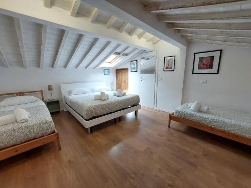 a bedroom with two beds and a wooden floor at Casa Vacanze Francesco in Florence