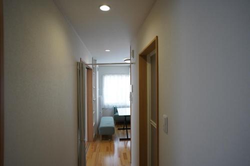 a hallway with a door leading to a room with a table at エル白馬 L hakuba in Hakuba