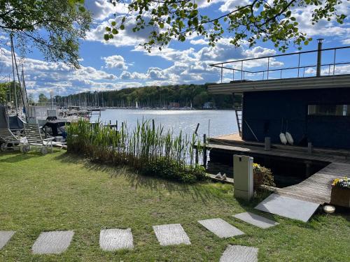 a dock with a boat on a body of water at Marina Hausboote und Seelodge in Berlin
