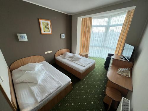 a hotel room with two beds and a television at Vila Crinul in Baile Felix