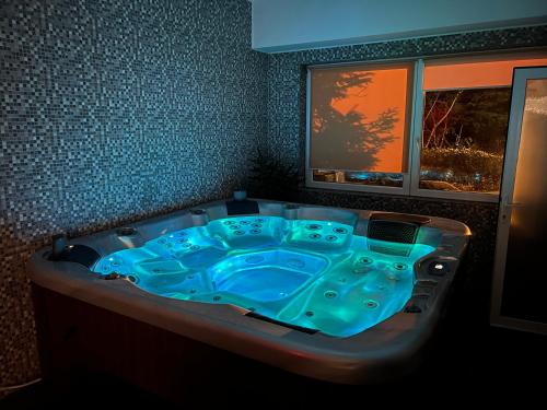 a blue bath tub in a room with a window at Vila Crinul in Baile Felix