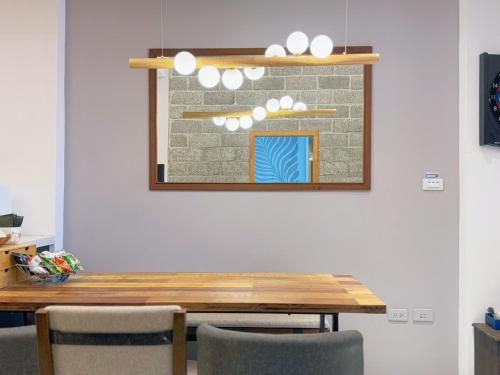 a dining room table with chairs and a mirror at Summer Station in Hualien City