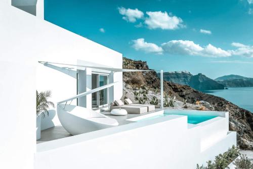 a white house with a swimming pool and a villa at The Saint Hotel in Oia