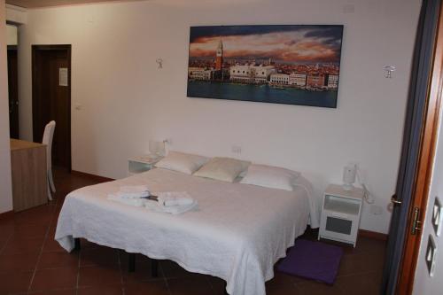 ein Schlafzimmer mit einem Bett mit einem Bild an der Wand in der Unterkunft B&B Airport Venice Diego 2 in Tessera