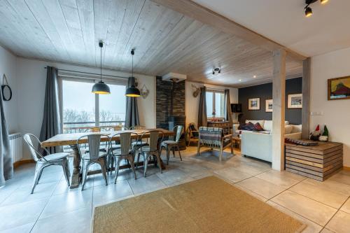 une salle à manger et un salon avec une table et des chaises dans l'établissement Chalet du Fey, à Valmorel