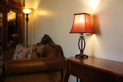 a lamp sitting on a table next to a couch at Central Hotel Radviliškis in Radviliškis