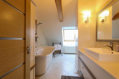 a bathroom with a tub and a sink and a mirror at Central Hotel Radviliškis in Radviliškis