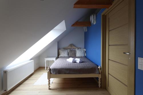a bedroom with a bed with a blue wall at Central Hotel Radviliškis in Radviliškis