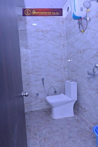 a bathroom with a toilet and a stone wall at Shri Ramnarayan Homestay in Prayagraj
