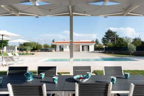 a black table with chairs and an umbrella at CHIALE Holiday Villa in Polignano a Mare