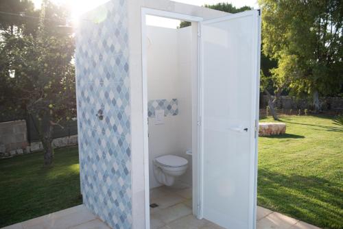 a bathroom with a toilet in an open door at CHIALE Holiday Villa in Polignano a Mare