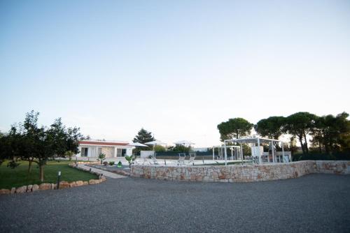 a driveway with a stone wall and a house at CHIALE Holiday Villa in Polignano a Mare