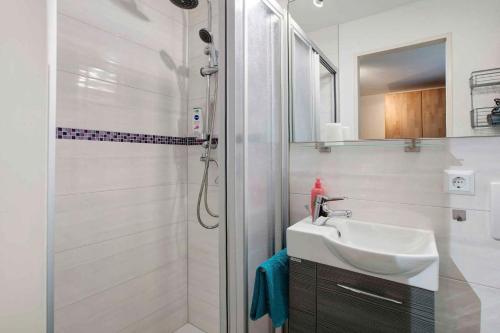 ein weißes Badezimmer mit Waschbecken und Dusche in der Unterkunft Apartment Todtmoos 3 in Todtmoos