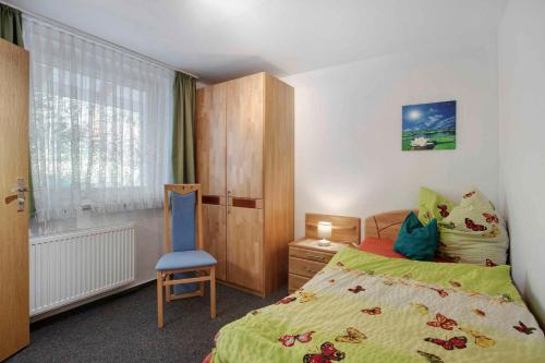 ein Schlafzimmer mit einem Bett und einem Stuhl und einem Fenster in der Unterkunft Apartment Todtmoos 3 in Todtmoos