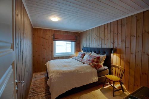 Un dormitorio con una cama y una ventana y una silla. en Luxury and comfort with stunning views, en Beitostølen
