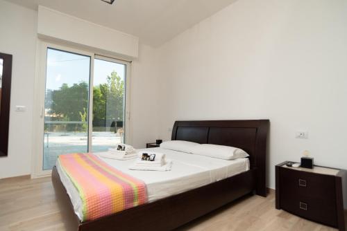 a bedroom with a large bed and a large window at CHIALE Holiday Villa in Polignano a Mare