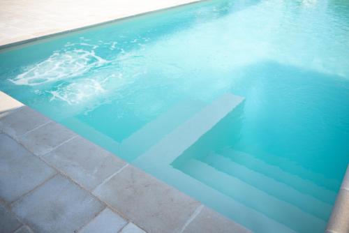 a swimming pool with a white x in the water at CHIALE Holiday Villa in Polignano a Mare