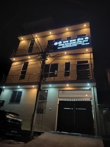 a building with a sign on top of it at night at Shree Ram Shabd Guest House in Ayodhya