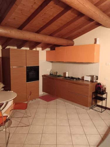 a kitchen with wooden cabinets and a table in it at Casa Giulia - Valeggio sul Mincio in Valeggio sul Mincio