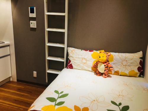 a teddy bear sitting on a bed in a bedroom at Okubo House 3F SJ0277 in Tokyo