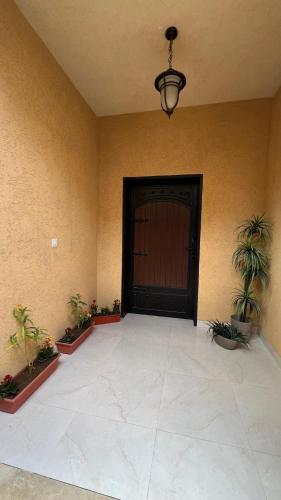 una habitación con una puerta negra y macetas en شقة غرفتين نوم وصالة وحديقة خارجية, en Riad