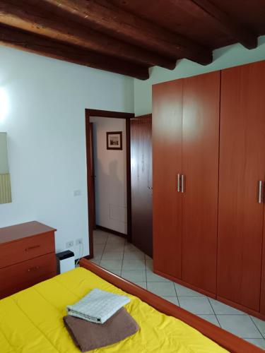 a bedroom with a yellow bed and wooden cabinets at Casa Giulia - Valeggio sul Mincio in Valeggio sul Mincio