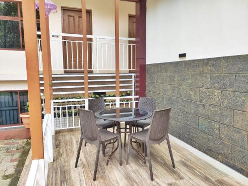 a patio with a table and chairs on a balcony at Mizzle Resort in Padinjarathara