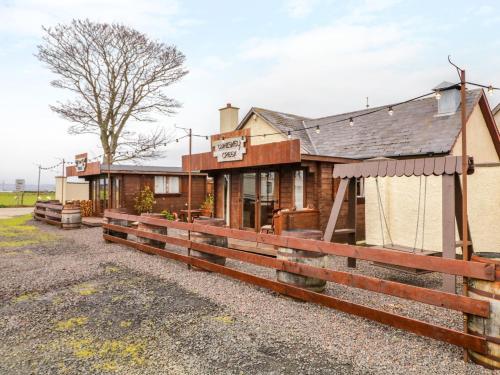 a building with a fence in front of it at Apache Falls Lodge in Limavady