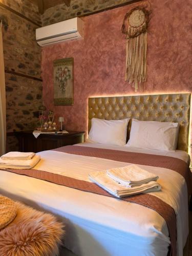 a bedroom with a bed with towels on it at Luxury Suites in Villa Anasia, Amaryllis in Skotina