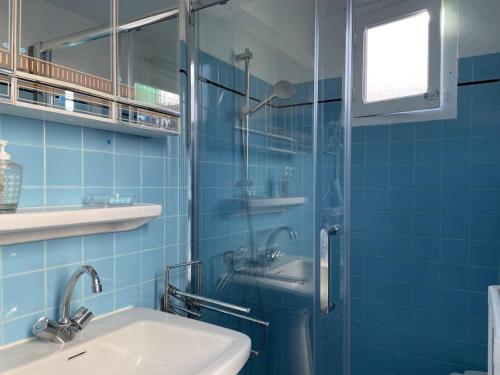 une salle de bain carrelée bleue avec un lavabo et une douche dans l'établissement Appart 3 pièces 5 couchages BANYULS SUR MER BN500-001, à Banyuls-sur-Mer