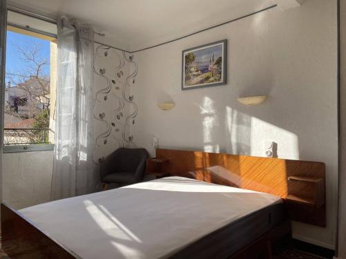 une chambre avec un lit, une fenêtre et une chaise dans l'établissement Appart 3 pièces 4 couchages BANYULS SUR MER BN500-002, à Banyuls-sur-Mer