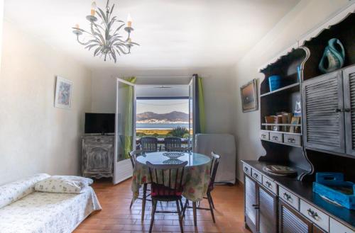 un salon avec une table, des chaises et un canapé dans l'établissement Studio pieds dans l'eau, à Grosseto-Prugna