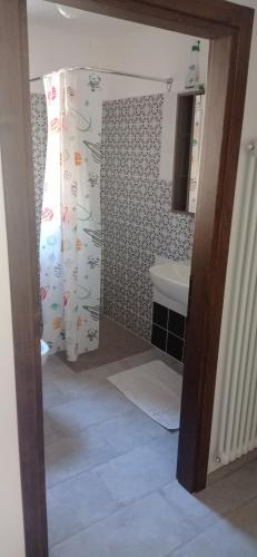 a bathroom with a shower curtain and a sink at Agriturismo IL CERRO in Marzabotto