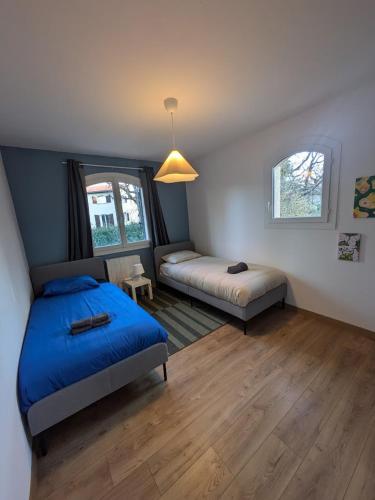 une chambre avec deux lits et une fenêtre dans l'établissement Maison T5 -Les reflets du lac - Terrasse -Piscine, à Aussonne