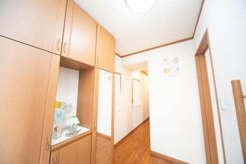 a room with a hallway with wooden cabinets at Miraie Yokkaichi Takasagocho in Yokkaichi