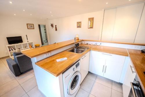 une cuisine avec une machine à laver et un évier dans l'établissement Lisa - Spacious Terrace Ground floor - by TGB, à Ajaccio
