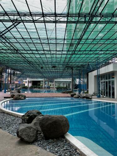 a large swimming pool with rocks in a building at Kasara Serenity Condotel in Manila