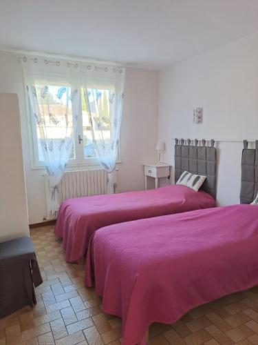 - 2 lits dans une chambre avec des draps violets dans l'établissement Villa la Galine, à Puimisson