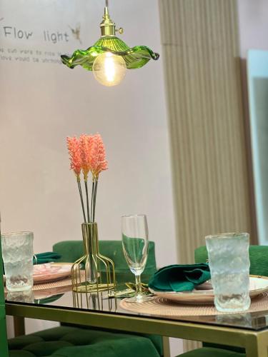 a table with a vase of flowers and glasses on it at Kasara Serenity Condotel in Manila