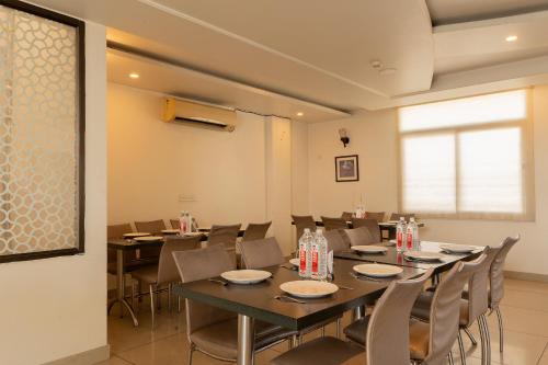 a dining room with tables and chairs and a window at FabHotel Signature Inn in Jaipur