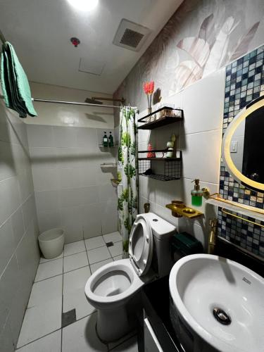 a bathroom with a toilet and a sink at Kasara Serenity Condotel in Manila