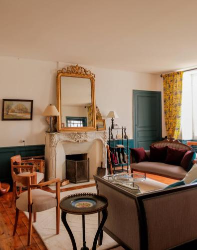 un salon avec une cheminée et un miroir dans l'établissement Oléron MaisonMer, au Château-dʼOléron